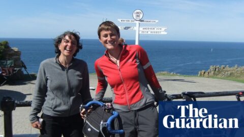 The couple with their bikes in front of a sign