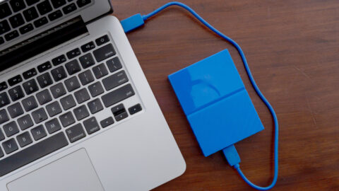 A blue external drive attached to a MacBook.