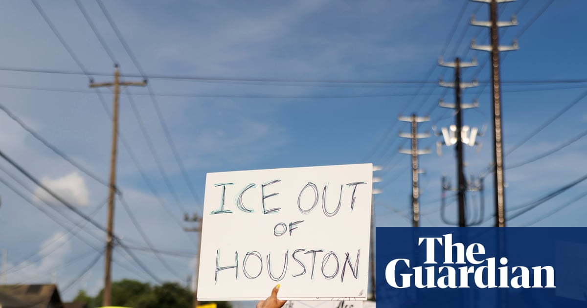 A woman holds a sign reading "ICE OUT OF HOUSTON" during a protest in July.